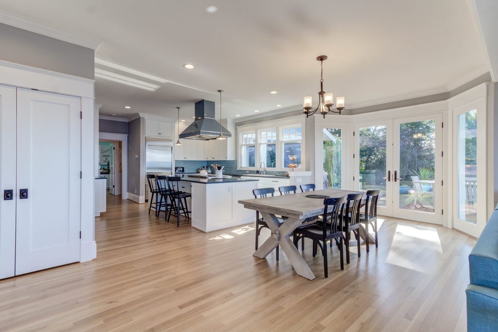 home remodel with new kitchen island with bar seating, dining room with new hardwood floors