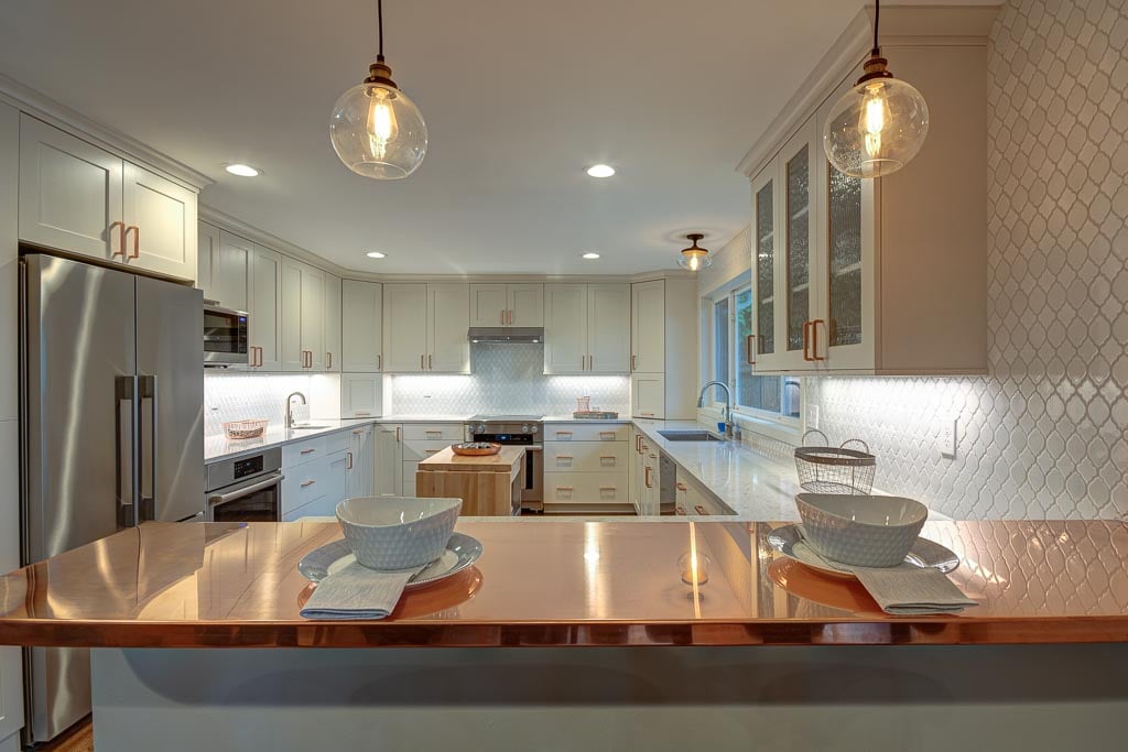 mixed metals kitchen featuring a copper bar top counter